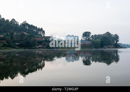 Am frühen Morgen Nebel stieg von See an Rutinda Dorf am Lake Bunyonyi im Südwesten von Uganda, Ostafrika Stockfoto