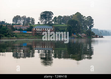 Am frühen Morgen Nebel stieg von See an Rutinda Dorf am Lake Bunyonyi im Südwesten von Uganda, Ostafrika Stockfoto