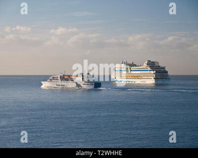 Die Insel Porto Santo Fähre und AIDA Stella Kreuzfahrtschiff verlässt Funchal Hafen auf Madeira nach Sonnenaufgang an einem klaren Morgen. Stockfoto