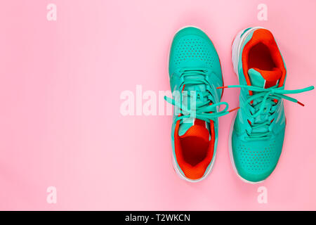 Rot, hellblau, weiß, Paar neue Tennisschuhe im Studio Schuß über rosa Hintergrund. Direkt von oben. Stockfoto