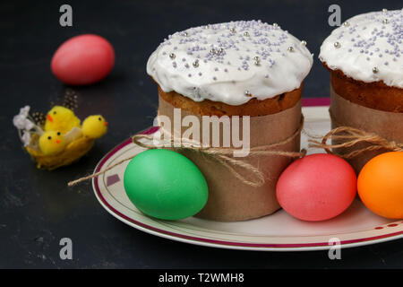 Ostern Kuchen und bunte Eier auf einer Platte auf einem dunklen Hintergrund befinden, horizontale Foto Stockfoto