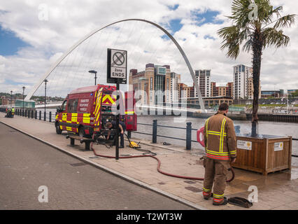 Ein Feuerwehrmann Bewältigung einer brennenden Palme an der Uferstraße, Newcastle Upon Tyne, England, UK Stockfoto