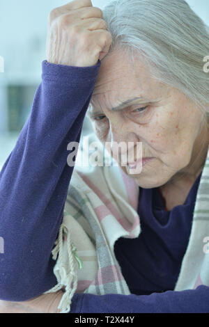 Close up Portrait von traurige ältere Frau am Tisch sitzen Stockfoto
