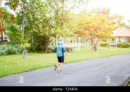 Nicht identifizierte Mann mittleren Alters Jogging im Park am Morgen Stockfoto