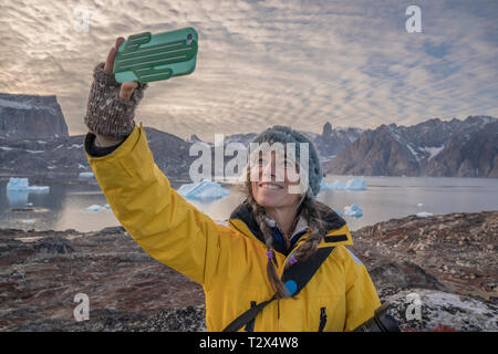 Frau eine selfie mit einem Handy, Scoresbysund, Grönland Stockfoto