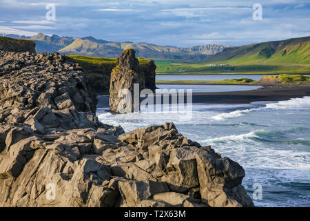 Malerische isländische Landschaft mit Arnardrangur (Eagle Rock) basalt Meer Stapel auf der Reynisfjara schwarzen vulkanischen Sand Strand in der Nähe von Vík í Mýrd Stockfoto