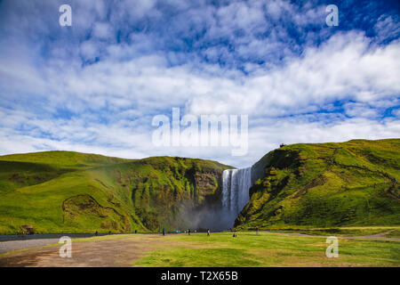 Touristen an der Skogafoss, einer der größten isländischen Wasserfälle auf der Skoga Fluss, eine beliebte Touristenattraktion im südlichen Island, Skandinavien Stockfoto