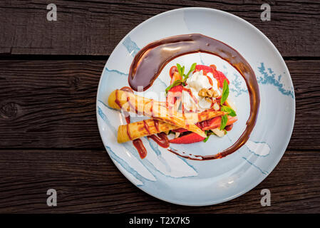 Eis Dessert mit Waffeln und Erdbeeren mit Zucker Pulver auf weißem Blech abgedeckt. Selektiver Fokus Stockfoto