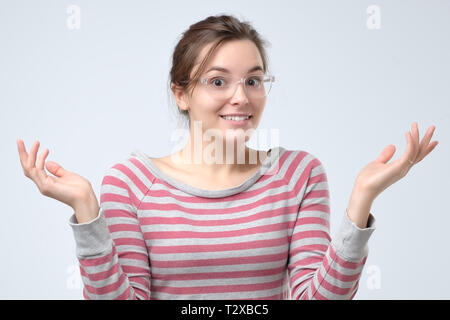 Europäische Frau zuckte mit Händen und Verwirrung zum Ausdruck zu bringen, die keine Ahnung von ihrer Frage. Es ist nicht mein Problem. Studio shot Stockfoto