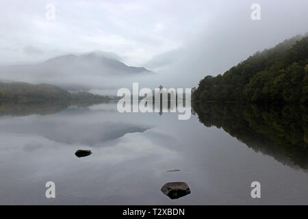 Loch Achray im Herbst Morgen mit Blick auf den Ben Venue eingehüllt in Nebel, Trossachs National Park, Schottland Stockfoto