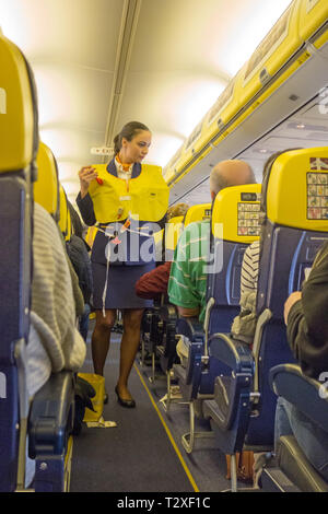 Frau weibliche Cabin Crew demonstriert die Notfall Sicherheit Verfahren bohren für Fluggäste, bevor Sie sich auf einen Ryanair Flug von Liverpool Stockfoto