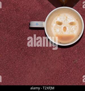 Eine weiße Schale, auf einem Teppich, mit einem Smiley mit Zitrone pip Augen und Kaffee, schlempen Mund entwickelt. Spaß zu unterhalten Kinder und Folk in eine festliche Stimmung. Stockfoto