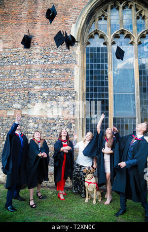 Chelmsford Cathedral, Studenten werfen ihre Mörser board Hüte in der Luft in der Feier von ihrer Grad vorbei. Stockfoto