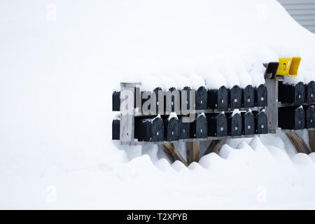 Mailboxen in einem großen Haufen Schnee von einem März Sturm abgedeckt Stockfoto