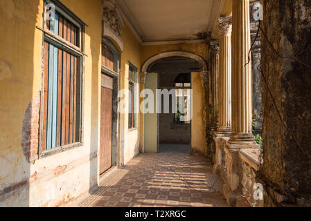 Passage mit gefliestem Boden und Zugenagelten Fenstern entlang der Spalten auf der zweiten Etage der Villa oder Villa Bodega. Stockfoto