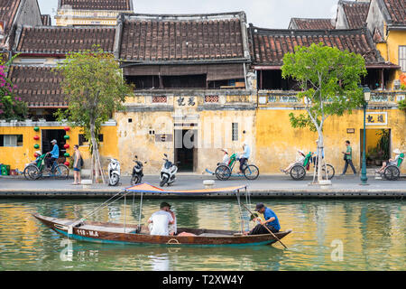 Hoi An, Vietnam - Oktober 28, 2018: Die alte Stadt am Fluss Straße mit Reisenden in einem Boot und Rikschas. Stockfoto