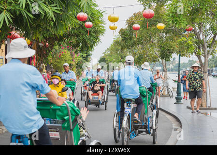 Hoi An, Vietnam - am 28. Oktober, 2018: Eine bunte Straße der Altstadt mit Zyklus Rikschas überfüllt. Stockfoto