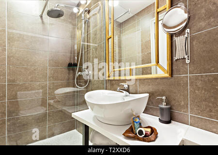 Modernes Interieur Badezimmer mit Waschbecken und Spiegel, Glas begehbare Dusche mit Marmor Fliesen Surround Stockfoto