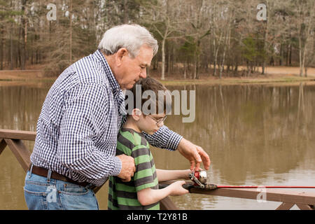 Ein 11-jähriger Junge lernen Fisch mit seinem Großvater auf einem See in Madison, Wisconsin, USA. Stockfoto