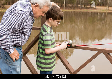 Ein 11-jähriger Junge lernen Fisch mit seinem Großvater auf einem See in Madison, Wisconsin, USA. Stockfoto