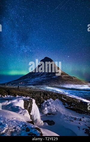 Aurora Borealis über Kirkjufellsfoss Wasserfall und kirkjufell, einen markanten Berg in Snaefellsnes Nationalpark auf der Halbinsel Snaefellsnes von Eis Stockfoto