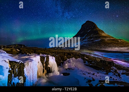 Aurora Borealis über Kirkjufellsfoss Wasserfall und kirkjufell, einen markanten Berg in Snaefellsnes Nationalpark auf der Halbinsel Snaefellsnes von Eis Stockfoto