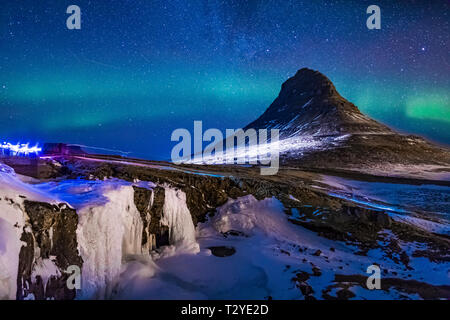 Aurora Borealis und Lichter von Touristen über Kirkjufellsfoss Wasserfall und kirkjufell, einen markanten Berg in Snaefellsnes Nationalpark auf der Snaefe Stockfoto