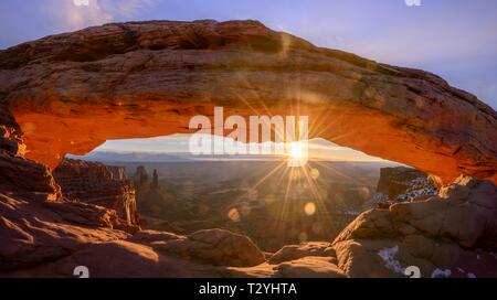 Blick durch arch Mesa Arch bei Sonnenaufgang mit sunstar, Colorado River Canyon mit der La Sal Mountains hinter, Blick auf Grand View Point Trail, Insel Stockfoto