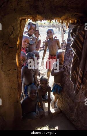 Viele neugierige Kinder in einem Himba Hütte, Kaokoveld, Namibia suchen Stockfoto