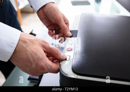 Nahaufnahme der Geschäftsmann und anschließend auf die Schaltfläche Drucker im Büro Stockfoto