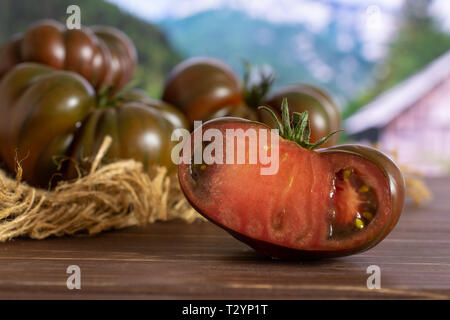 Menge insgesamt die Hälfte der frischen Tomate primora auf Jute Tuch mit Land Natur im Hintergrund Stockfoto