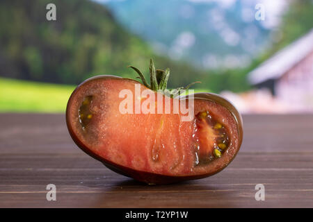 Die Hälfte der frischen Tomate primora mit Land Natur im Hintergrund Stockfoto
