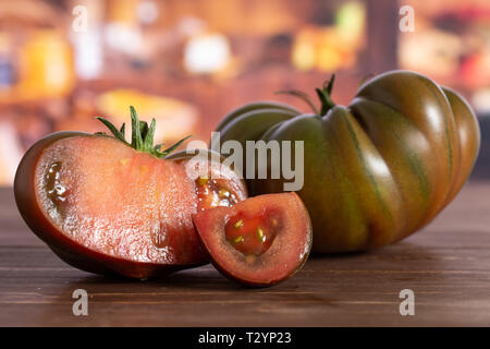 Gruppe von einer ganzen Hälfte eine Scheibe frischen Tomaten primora in eine rustikale Küche Stockfoto