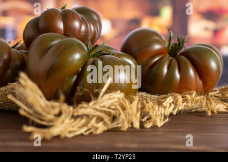 Menge ganze frische Tomaten primora auf Jute Tuch in eine rustikale Küche Stockfoto