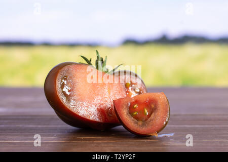 Gruppe von der einen Hälfte eine Scheibe frischen Tomaten primora mit grünen Weizenfeld Stockfoto