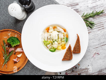 Aromatische Suppe mit Hähnchen und Brokkoli. Und zwei Stücke Brot in der Form von Dreiecken. Flay legen. Ansicht von oben Stockfoto