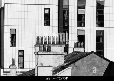 Schornstein Töpfe auf dem Dach eines Hauses gegen die weißen Fassade eines Bürogebäudes eingestellt Stockfoto