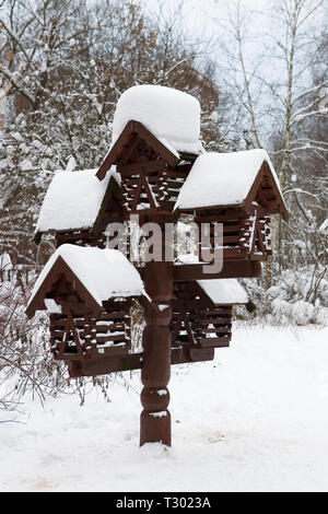 Schöne hölzerne Feeder für Vögel und Eichhörnchen im Winter Wald. Die Sorge um die Natur. Stockfoto