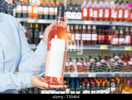 Frau kauft Wein im Shop Stockfoto