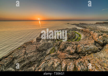 Sonnenaufgang über dem Meer an der Priester Badewanne (Prastens Badkar) sand Vulkan Bildung an der Küste von. Vik, Simrishamn, Skåne, Schweden, Skandinavien. Stockfoto