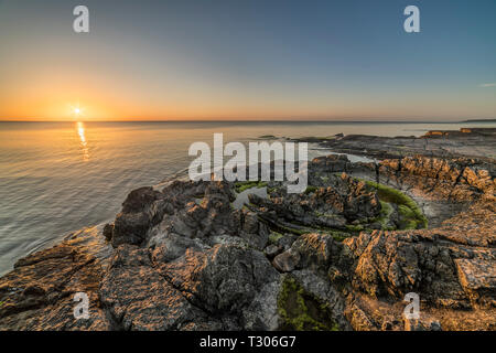 Sonnenaufgang über dem Meer an der Priester Badewanne (Prastens Badkar) sand Vulkan Bildung an der Küste von. Vik, Simrishamn, Skåne, Schweden, Skandinavien. Stockfoto