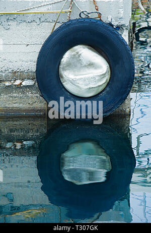 Wand Guard für Dock Stoßfänger auf Marina Wand mit Reflexion an der Oberfläche des Wassers. Stock Bild. Stockfoto