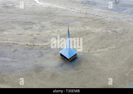 Antenne drone Ansicht der orthodoxen Kirche mit giftigen Abfall Wasser geflutet, Bergbau, chemische Rückstände, Schlamm. Ökologische Bombe, Geamana, Rumänien Stockfoto