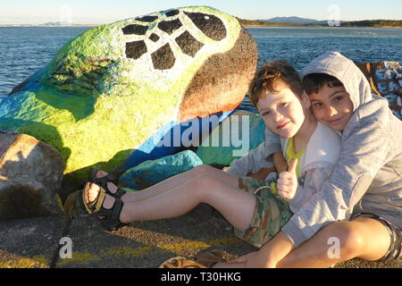 2 Jungen vor einem Fels, bei dem sie in Nambucca Heads pause Wand gemalt, New South Wales, Australien Stockfoto