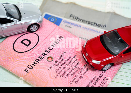 Miniatur Autos auf alte und aktuelle deutsche Führerscheine, Miniaturautos auf alten und beantragten aktuellen deutschen Führerscheinen Stockfoto