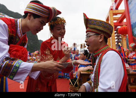 Du'an, China Guangxi Zhuang autonomen Region. 4 Apr, 2019. Ein 'paar' behandeln Ihre "Vater" mit Fleisch während einer Leistung der Hochzeit brauch der Zhuang ethnische Gruppe in Du' ein Yao autonomen County, South China Guangxi Zhuang autonomen Region, 4. April 2019. Credit: Lu Boan/Xinhua/Alamy leben Nachrichten Stockfoto