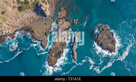 Luftaufnahme, Top Shot der große Wellen schlagen die Felsen am Strand im Great Barrier Island, Neuseeland Stockfoto