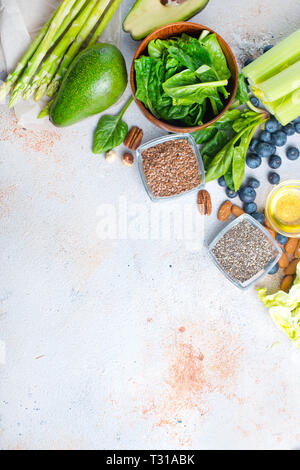 Gesundes Essen. Grünes Gemüse, Nüsse und Chia Samen auf einem Tisch Stockfoto