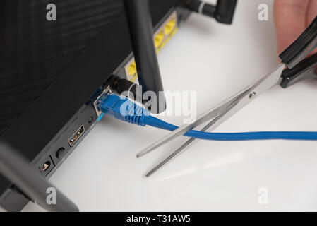 Netzwerk- und Datensicherheit Konzept mit einer Schere. Internet Router oder mit Kabel Schalter angeschlossen. Stockfoto