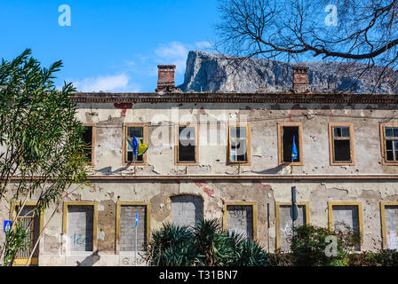 Gebäude in der Stadt Mostar, die durch den Krieg beschädigt und noch nicht renoviert. Durch die Einschusslöcher ruiniert, Mörtel Bombe shell Granate beschädigt Stockfoto